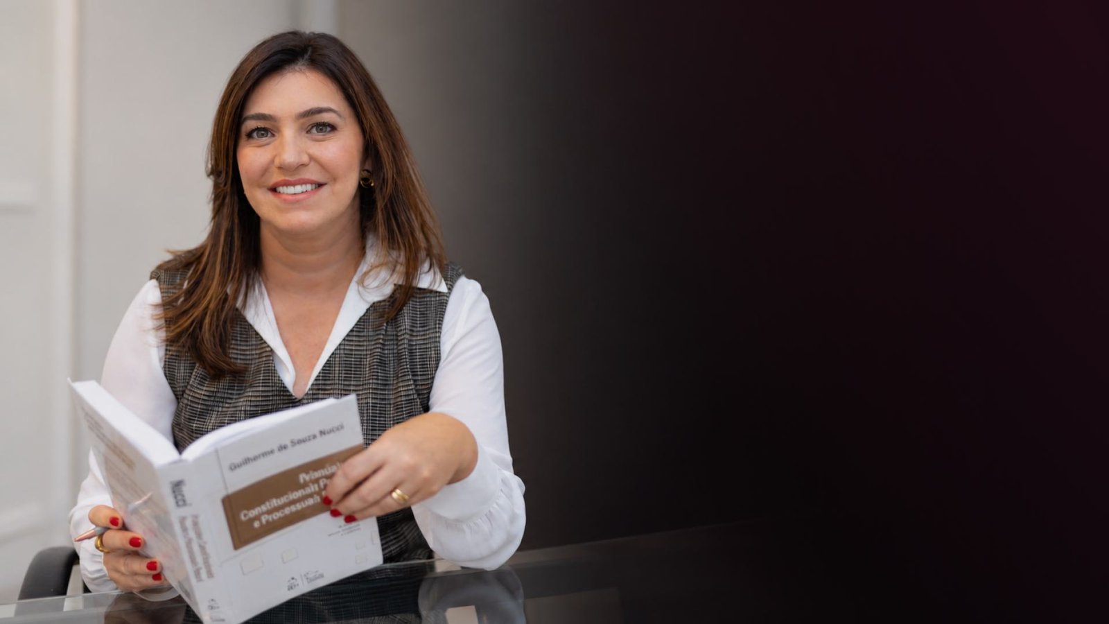 Prof.ª Marina Della Torre com um livro de Processo Penal