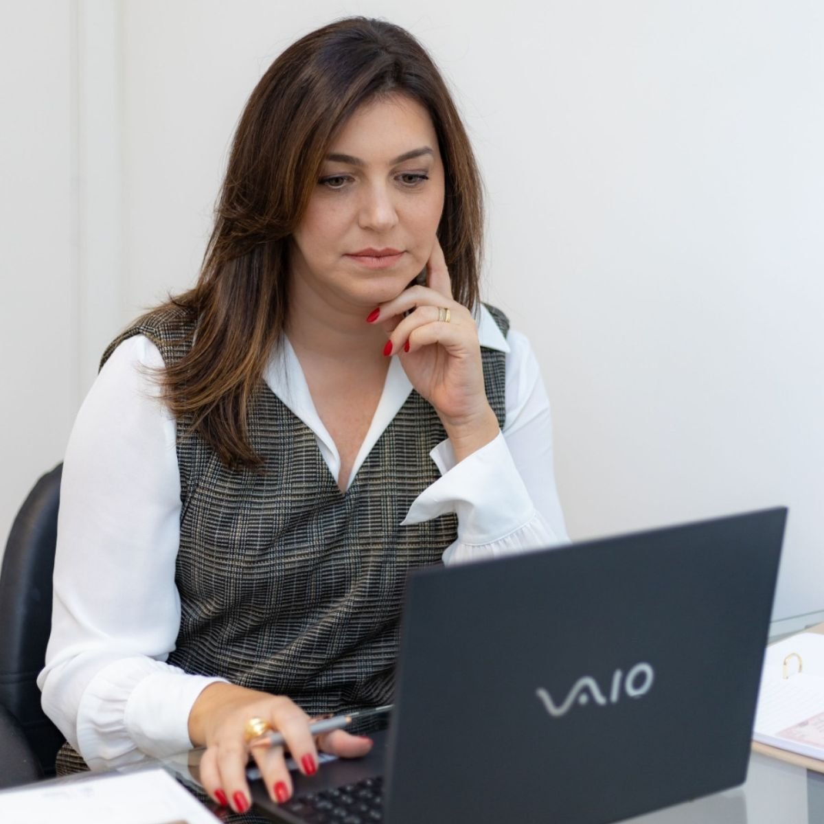 Prof.ª Marina Della Torre corrigindo peças no computador